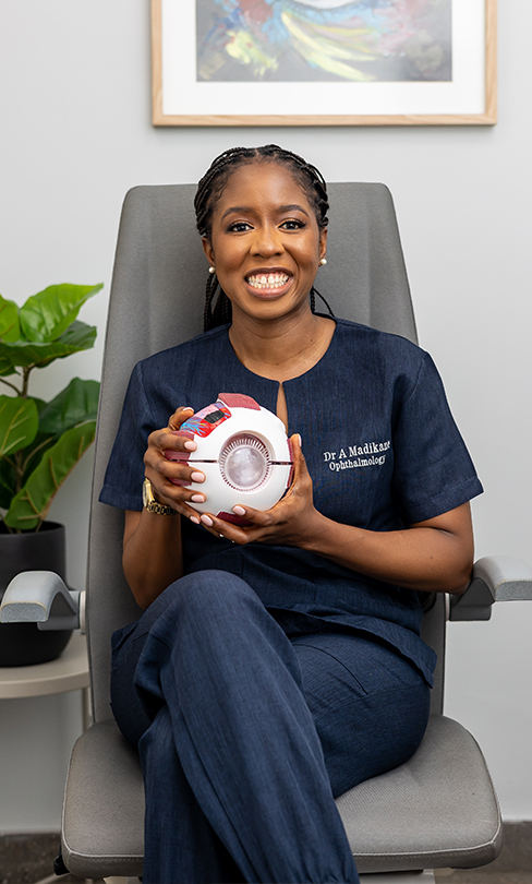 Dr Anesu Madikane holding a Magnification of the Human Eye Model.